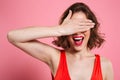 Close-up portrait of charming smiling brunette woman hiding eyes