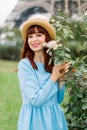 Close up portrait of charming smiling young red haired woman, wearing blue elegant dress and stylish straw hat, posing Royalty Free Stock Photo