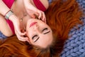 Close-up portrait of a Charming woman with red hair lying on the bed Royalty Free Stock Photo