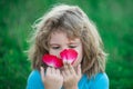 Close-up portrait of cheerful child smelling flowers. Cute joyful little boy kid. Close up portrait of funny little