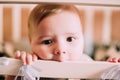 Close-up portrait of a cheerful cute baby in the crib at home Royalty Free Stock Photo