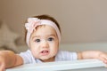 Close-up portrait of a cheerful cute baby in the crib at home, white decoration Royalty Free Stock Photo