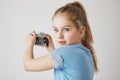 Close up portrait of cheerful cute girl with blonde hair and blue eyes, looking in camera with interested expression