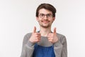 Close-up portrait of cheerful enthusiastic male employee agrees with coworker, show thumbs-up and smiling pleased, give