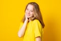 Portrait of a cheerful girl. Happy smiling teenage girl on a yellow background Royalty Free Stock Photo