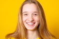 Close-up portrait of a cheerful girl. Studio portrait of a smiling teenage girl on a yellow background Royalty Free Stock Photo