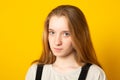 Close-up portrait of a cheerful girl. Studio portrait of a smiling teenage girl on a yellow background Royalty Free Stock Photo