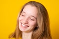 Close-up portrait of a cheerful girl. Studio portrait of a smiling teenage girl on a yellow background Royalty Free Stock Photo