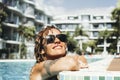 Close up portrait of cheerful happy woman smiling and relaxing at the pool in hotel resort accomodation rooms. Travel and summer Royalty Free Stock Photo