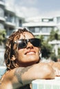 Close up portrait of cheerful happy woman smiling and relaxing at the pool in hotel resort accomodation rooms. Travel and summer Royalty Free Stock Photo