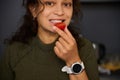 Close-up portrait of a cheerful multi ethnic woman eating ripe organic and juice tomato cherry, smiles looking at camera Royalty Free Stock Photo