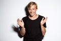 Close up portrait of cheerful smiling blond handsome young man wearing black t-shirt clapping hands isolated on white Royalty Free Stock Photo