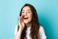 Close up portrait of cheerful young woman calling someone, holding hand near opened mouth while shouting, searching for Royalty Free Stock Photo