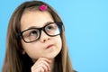 Close up portrait of a child school girl wearing looking glasses holding hand to her face thinking about something isolated on