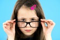 Close up portrait of a child school girl wearing looking glasses isolated on blue background