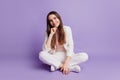 Close up portrait of clever creative lady sit floor hand chin think look camera posing on purple wall