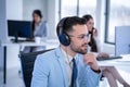 Close up portrait of concentrated young male customer support operator with headset and eyeglasses at call center. Royalty Free Stock Photo