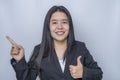 Close-up portrait of confident adult businesswoman showing thumb up with hand to presenting or pointing isolated on grey Royalty Free Stock Photo