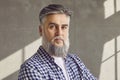 Close up portrait of confident bearded mature man on grey wall background Royalty Free Stock Photo