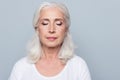 Close up portrait of confident concentrated mature woman with wrinkles on face, with closed eyes, with nude make up, isolated on Royalty Free Stock Photo