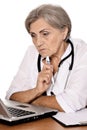 Close up portrait of confident female doctor sitting at table on white Royalty Free Stock Photo