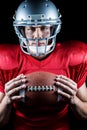 Close-up portrait of confident sportsman holding American football