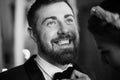 Close up portrait of a confident young man with beard smiling. bride groom straightens his tie