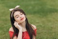 Closeup portrait of content young beautiful woman wearing headphones, listening to music with her eyes closed and lying Royalty Free Stock Photo