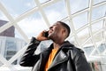 Close up young african american man talking and laughing on mobile phone in city Royalty Free Stock Photo