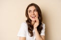 Close up portrait of coquettish beautiful girl gazing silly, gently smiling and giggling, posing flirty and cute against Royalty Free Stock Photo