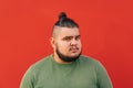 Close up portrait of a corpulent handsome guy, looking at the camera with serious expression. Shot on a red background Royalty Free Stock Photo