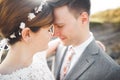 Close up portrait of couple against river and green trees. Beautiful young woman kissing handsome man outdoors Royalty Free Stock Photo