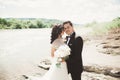 Close up portrait of couple against river and green trees. Beautiful young woman kissing handsome man outdoors Royalty Free Stock Photo