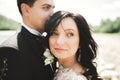 Close up portrait of couple against river and green trees. Beautiful young woman kissing handsome man outdoors Royalty Free Stock Photo