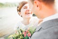 Close up portrait of couple against river and green trees. Beautiful young woman kissing handsome man outdoors Royalty Free Stock Photo