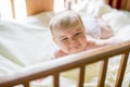 Close-up portrait of a crying cute baby in the crib at home