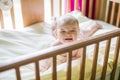 Close-up portrait of a crying cute baby in the crib at home