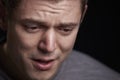 Close up portrait of crying young white man looking down