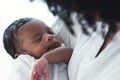 Close up portrait of cute African american newborn infant baby lying in mother's arms at hospital. Black Mother hand lulling Royalty Free Stock Photo