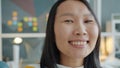 Close-up portrait of cute Asian lady busiesswoman looking at camera in office