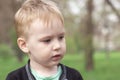 Close up portrait of cute ÃÂ¡aucasian baby boy on green park background.