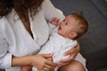 Close-up portrait of a cute baby boy smiling in the hands of his loving caring mother. Royalty Free Stock Photo