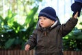 Baby Boy Wearing A Blue Knit Winter Hat And Green Winter Parka Royalty Free Stock Photo
