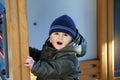 Baby Boy Wearing A Blue Knit Winter Hat And Green Winter Parka Royalty Free Stock Photo