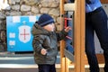 Baby Boy Wearing A Blue Knit Winter Hat And Green Winter Parka Royalty Free Stock Photo