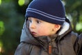 Baby Boy Wearing A Blue Knit Winter Hat And Green Winter Parka Royalty Free Stock Photo