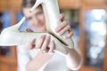 Close up portrait of cute bride girl holding wedding shoes in form heart in her hand Royalty Free Stock Photo