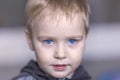 Close up portrait of cute caucasian baby boy with very serious face expression. Bright blue eyes, fair hair. Strong emotions. Royalty Free Stock Photo