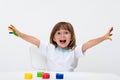 Close-up portrait of a cute cheerful happy smiling little girl draws her own hands with gouache or finger paints isolated on white Royalty Free Stock Photo