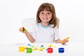 Close-up portrait of a cute cheerful happy smiling little girl draws her own hands with gouache or finger paints isolated on white Royalty Free Stock Photo